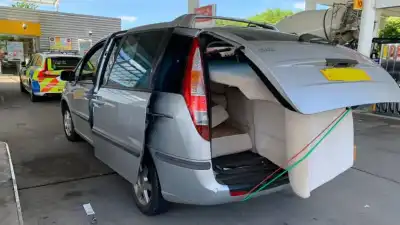Car driving with two unsecured sofas hanging out of the rear, and side, pulled over by police on the motorway